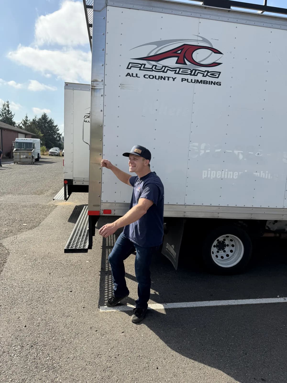 Josh knocking on the side of a box truck and grinning