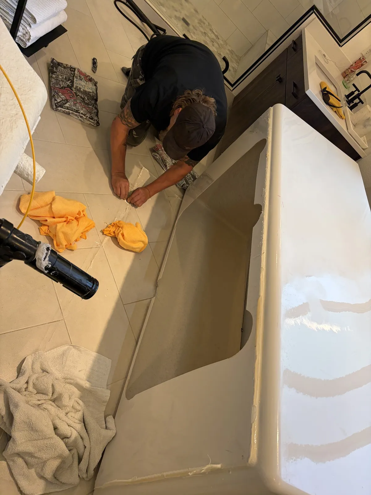 Technician kneeling beside a new alcove tub during installation