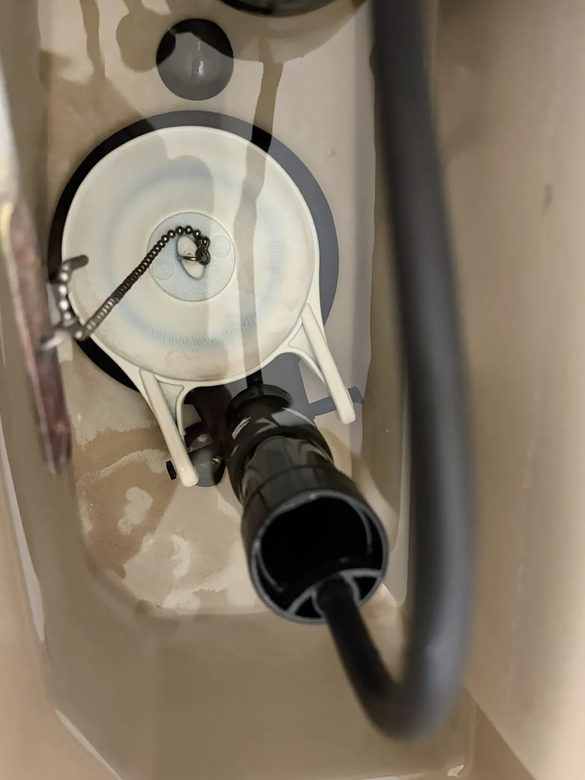 Close-up of a toilet tank flapper and chain